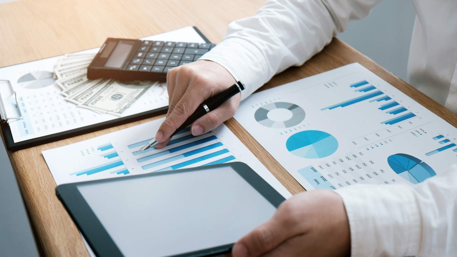 Persona revisando gráficos financieros y datos de continuidad operativa en una tablet
