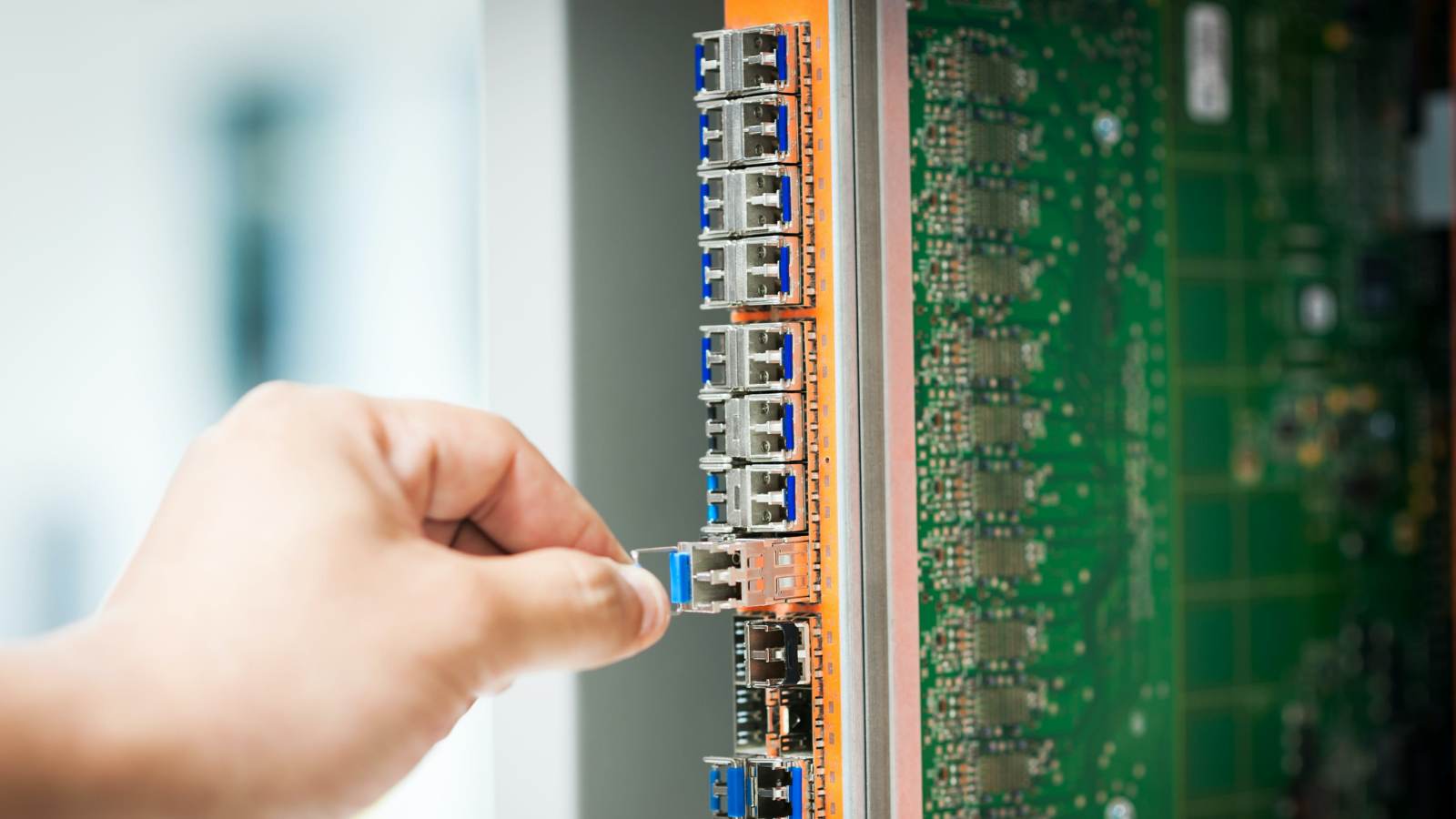 Técnico conectando un módulo de red a un equipo de servidores en un centro de datos