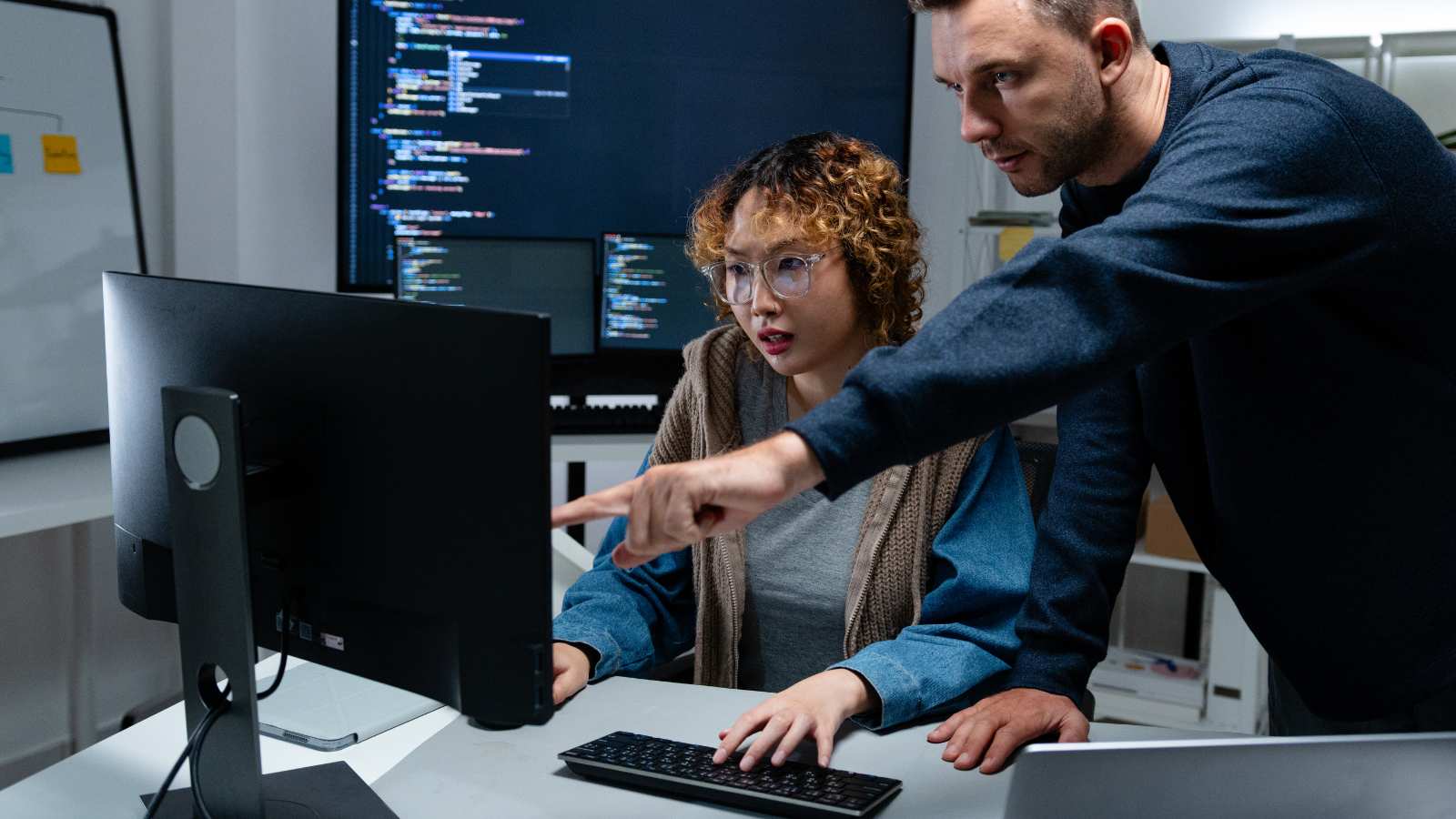 Dos desarrolladores revisando código en pantalla, representando un equipo de outsourcing TI