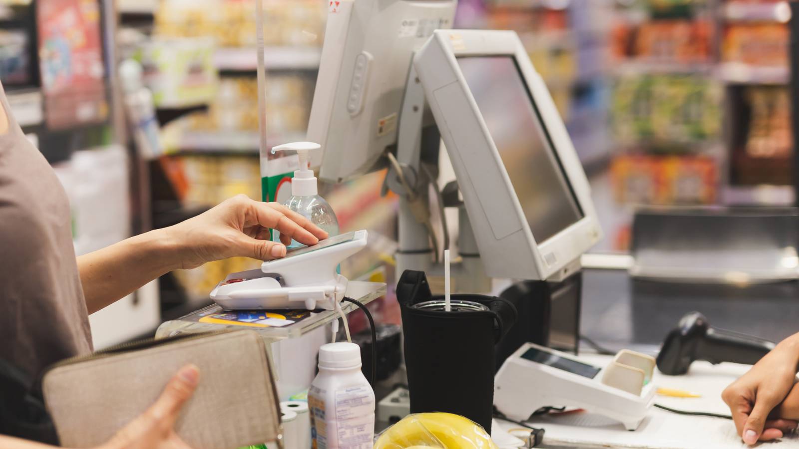 Cliente pagando con tarjeta en el lector de una caja de tienda retail